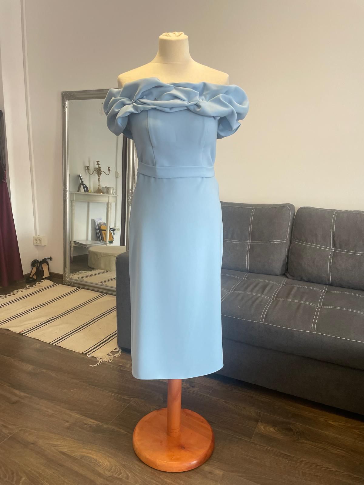 Model albastru deschis cu croială dreaptă, decolteu tip bardot și drapaje delicate la nivelul umerilor